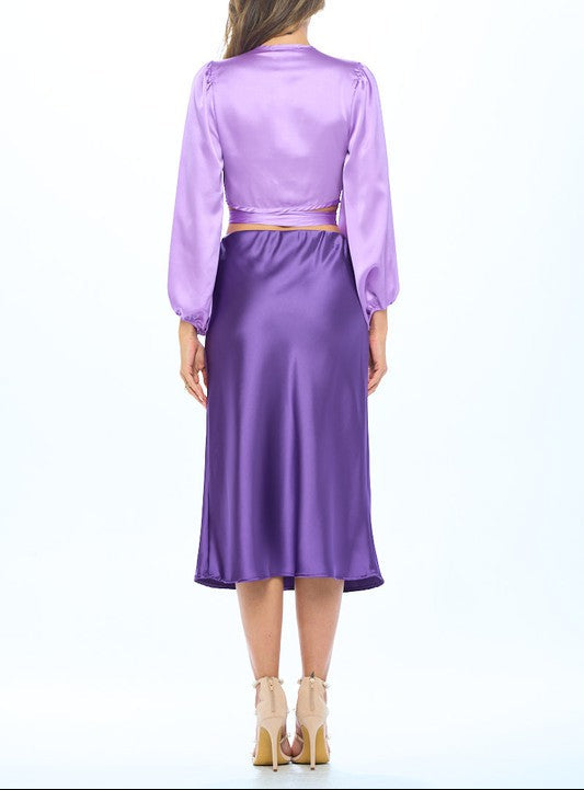 Woman wearing a purple satin outfit on a white background