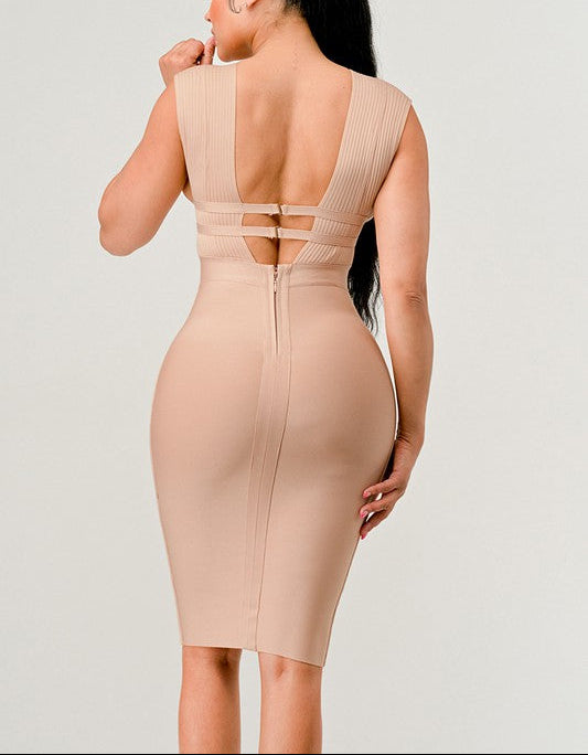 Beige dress with open back worn by a model on a plain background