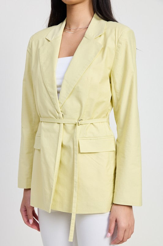 Light yellow blazer worn by a person on a white background