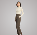 Woman wearing a cream turtleneck and brown pants on a gray background