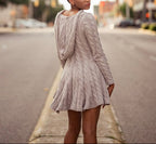 Woman in a gray dress standing on a city street